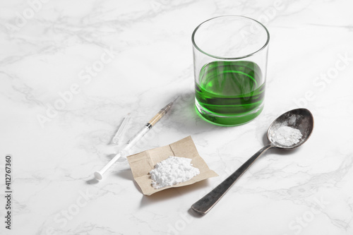 cocaine in paper and equipment on white background with a blank space for a text