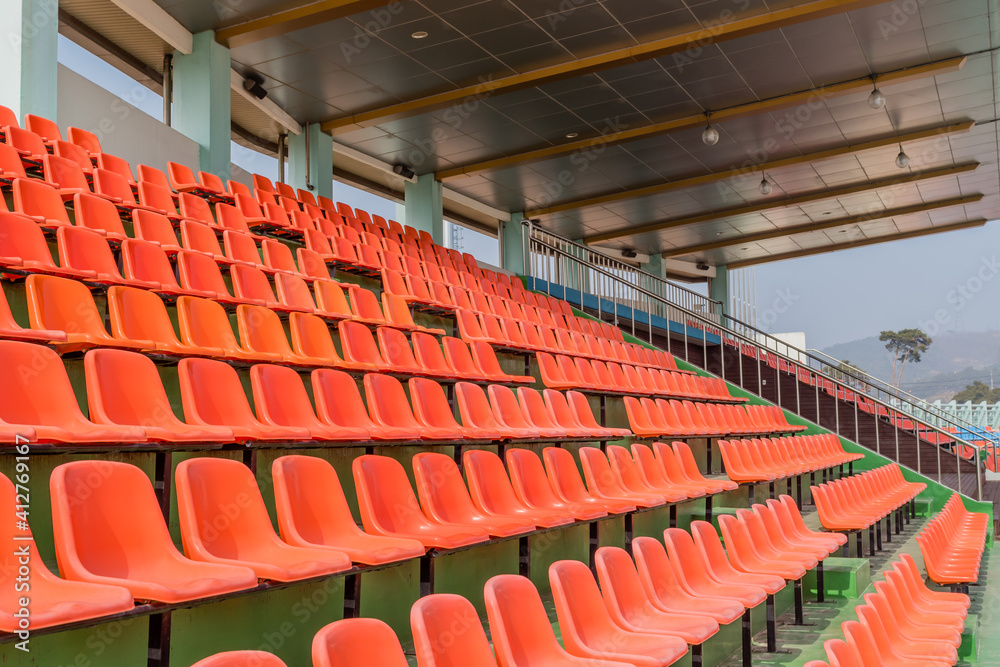 Empty orange stadium seats at sports complex