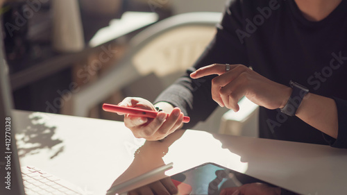 Close up of man using mobile phone on the table at the office.