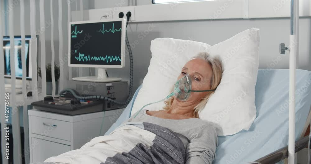 Doctor caring sick patient in hospital checking vital signs on monitor