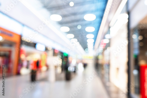 Abstract blurred background of modern luxury department store hall or shopping center mall. Blurred lights background. Blurred defocused bokeh lights with modern white interior architecture