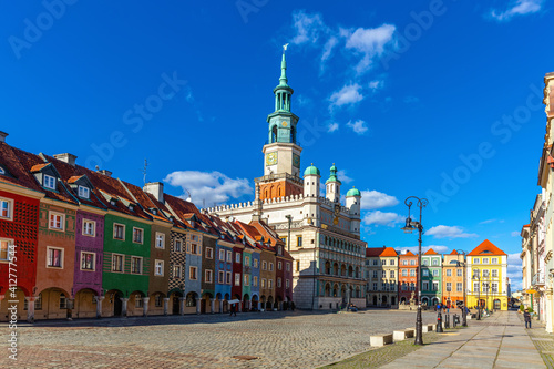 Renaissance building of historic Poznan Town Hall surrounded by colorful townhouses in Market Square in sunny day, Poland
