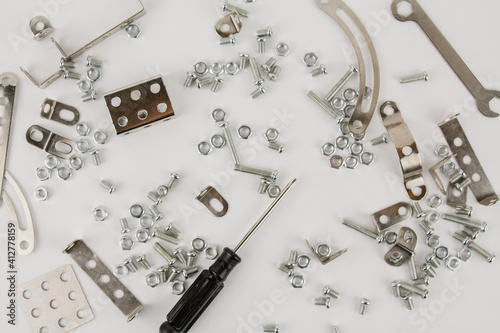 children's iron constructor with nuts and screws and a screwdriver on a white background