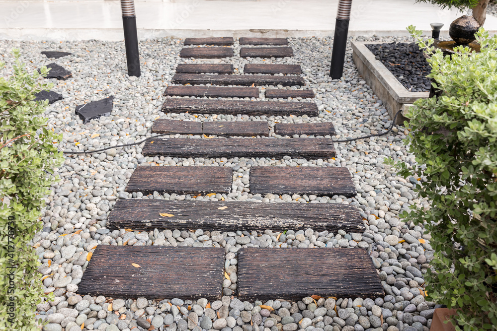 Stone walkway winding in garden. Stone block pathway and gray gravel in the park. landscape path in the garden. Stone walkway winding in garden. Stone block pathway and gray gravel in the park. landscape path in the garden.