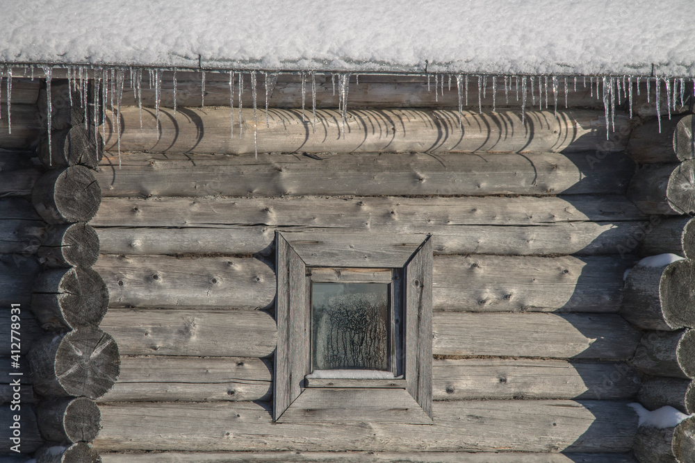 a wooden log house with icicles hanging from the roof