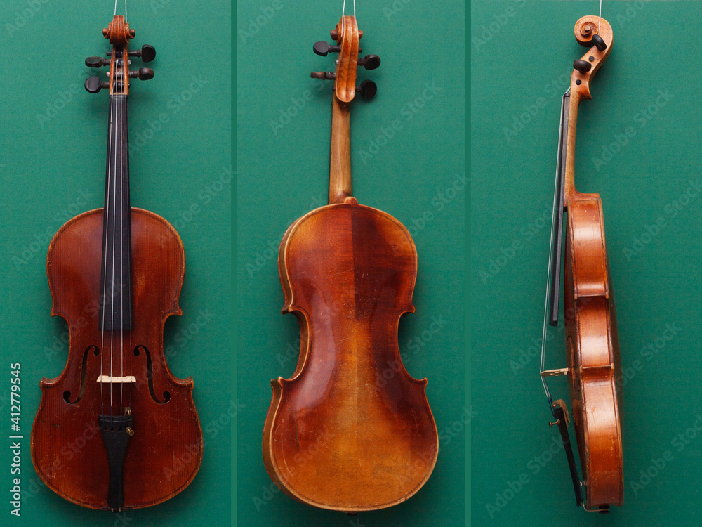 Antique fine violin from front, back and side on green background Stock