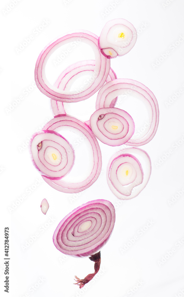 onion cut into rings drops on white background