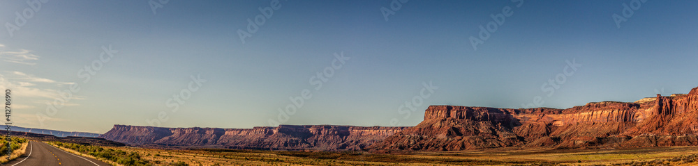 Panorama shot of long orange sandy massif of rock and road to canyonlands in utah, america