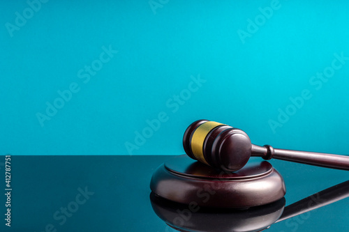 Valokuva Close-up Of Gavel And Sounding Block On Table Against Blue Background