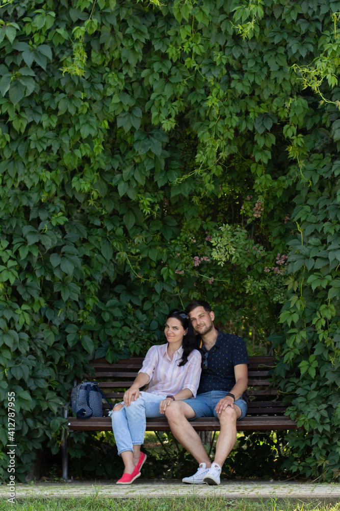 a guy with a girl sitting on a bench in the park in summer a guy with a girl sitting on a bench in the park in summer