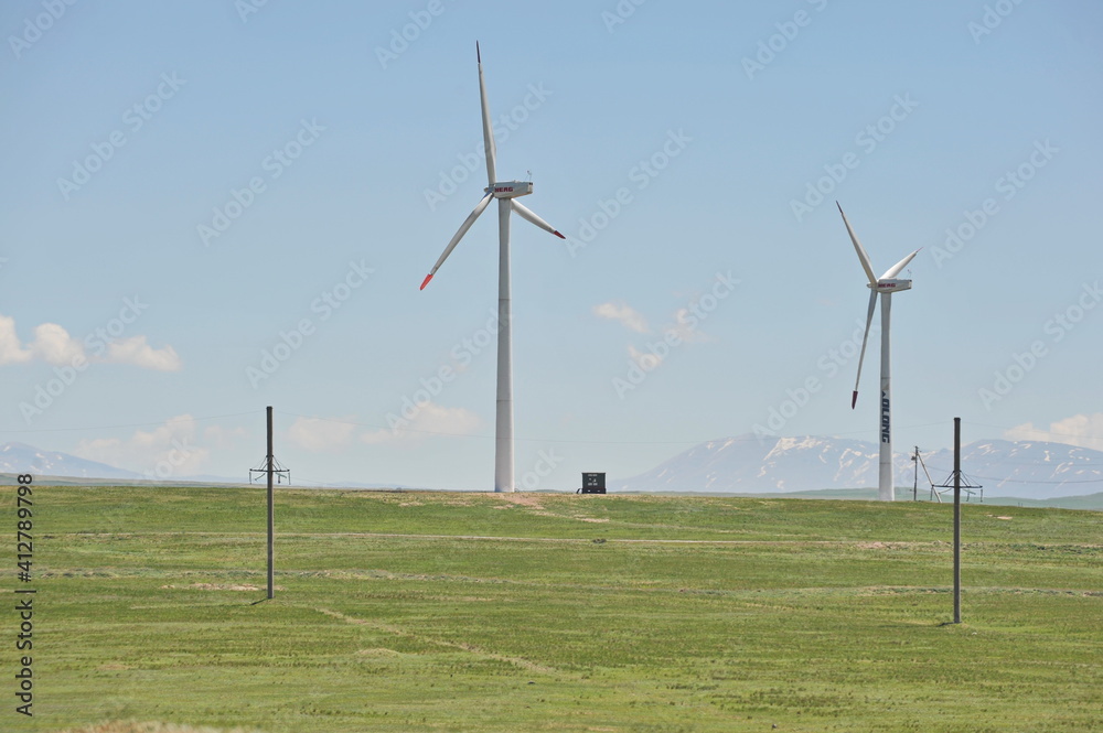 Fototapeta premium Zhambyl region, Kazakhstan - 05.15.2013 : Wind turbines located in an open hilly area to collect energy.