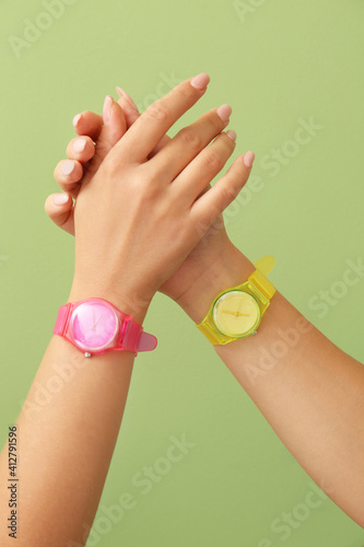 Female hands with wrist watches on color background, closeup © Pixel-Shot