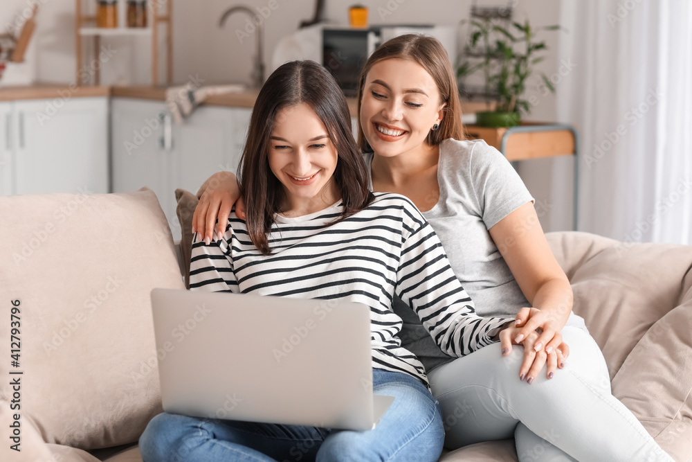 Young lesbian couple video chatting with friends at home Young lesbian couple video chatting with friends at home