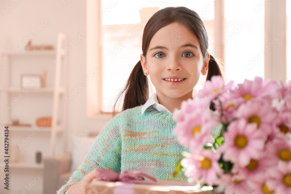 Cute little girl with bouquet of beautiful flowers and gift at home Cute little girl with bouquet of beautiful flowers and gift at home