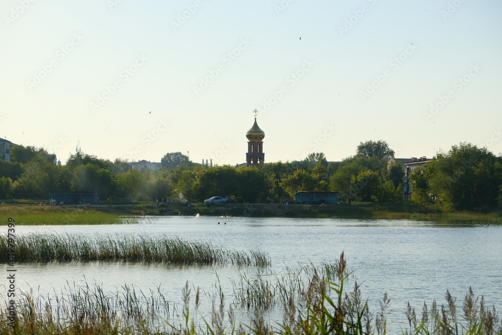 a church in the distance, a lake in the foreground