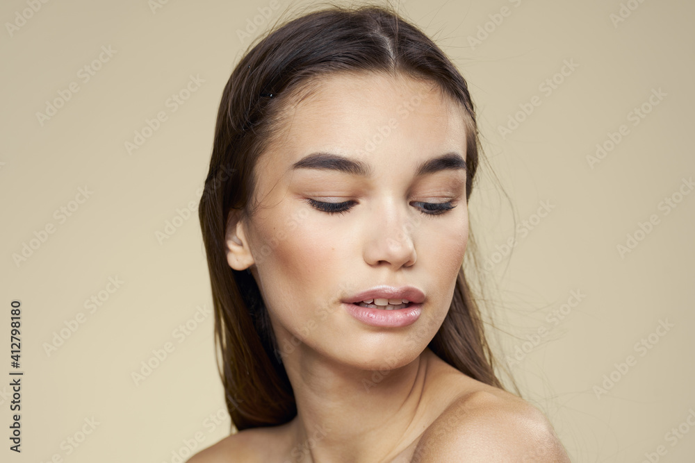Pretty woman naked shoulders long hair body care beige background Pretty woman naked shoulders long hair body care beige background
