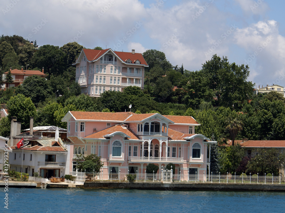 A view from Istanbul`s Bosphorus white mansion under the cloudy sky. The mansion is placed inside the forests. Istanbul has mansions like that along its seashore.