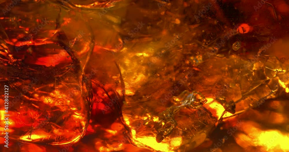Extreme close up macro shot of ice cubes rotating in golden colored liquid with bubbles. Whiskey with cola. Alcoholic drink concept Extreme close up macro shot of ice cubes rotating in golden colored liquid with bubbles. Whiskey with cola. Alcoholic drink concept