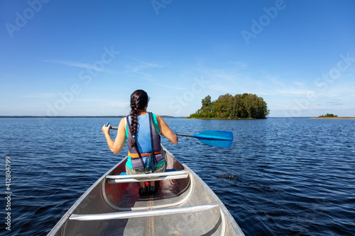 Attraktive Frau im Kanu erkundet den Bolmensee in Schweden photo