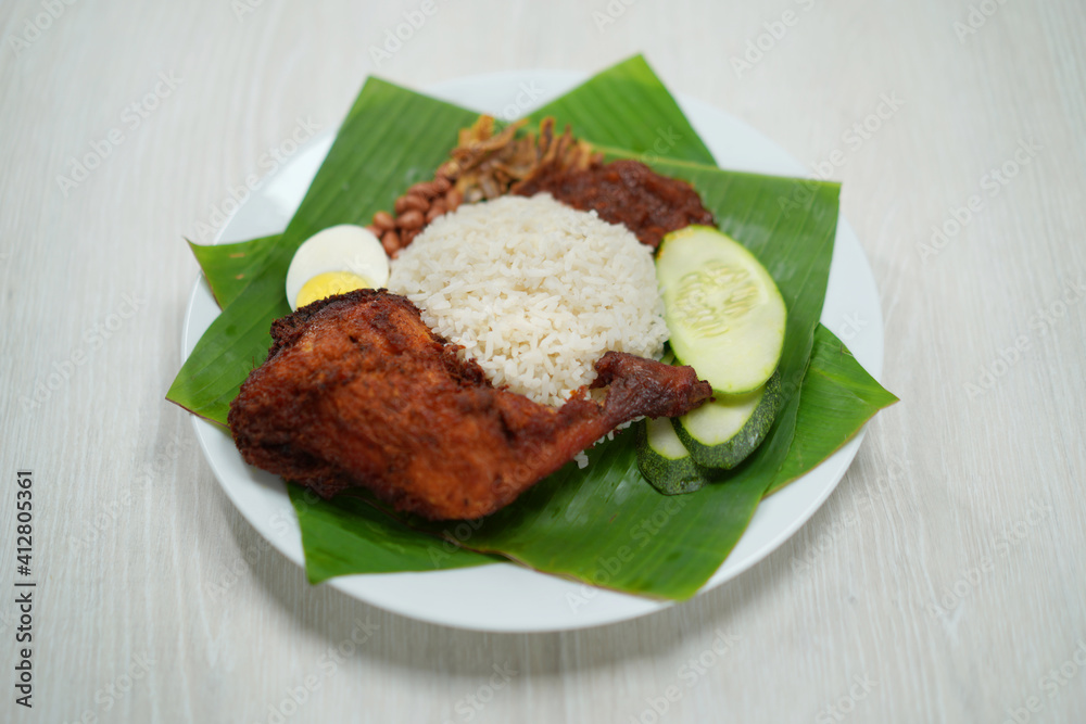 Nasi Lemak dish with chicken drum stick on white wooden verneer Nasi Lemak dish with chicken drum stick on white wooden verneer
