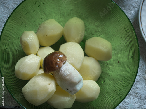 Boletus mushroom on the background of fresh potatoes ready for cooking.
