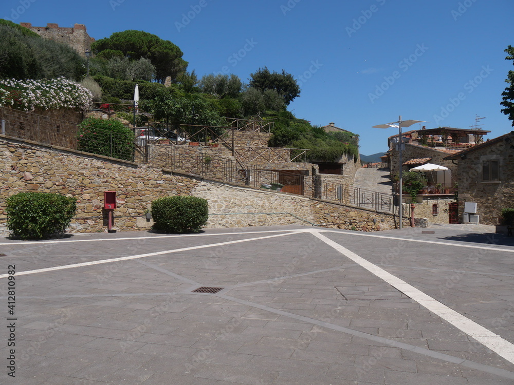 Solti Square of Castiglione della Pescaia with a street that goes up to the Castle and a road that goes down between the houses.