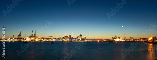 Sonnenuntergang der Skyline von Auckland mit Skytower und Hafen