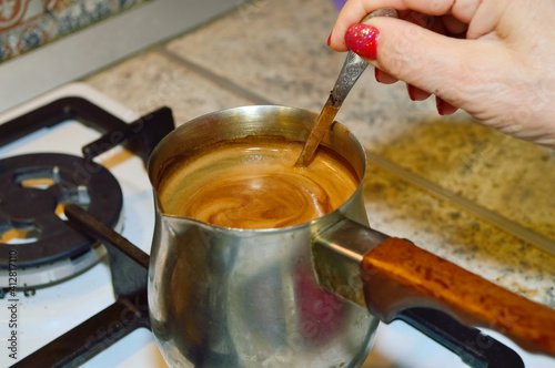 close-up - a woman is making fresh ground coffee, holding a small spoon in her hand