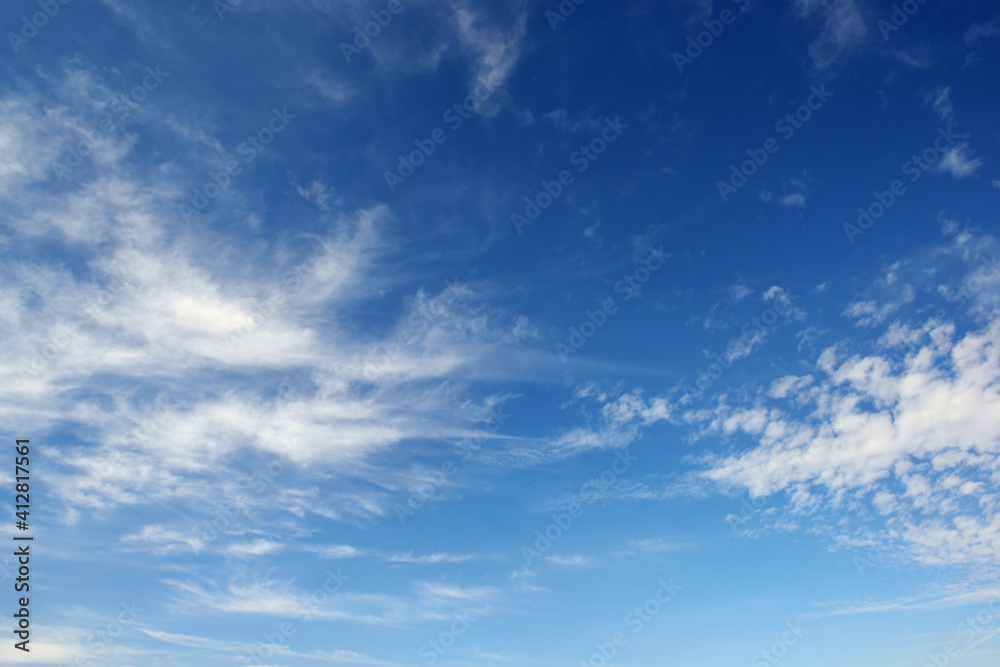 White cirrus clouds against the dark blue sky.