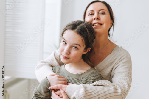 Attractive mother middle age woman and daughter teenager together in the light interior