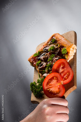 Serving pizzza on wooden plate. Just baked slice of pizza. photo