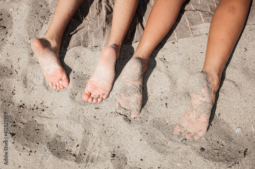 Kids feets in sand on a beach in summer
