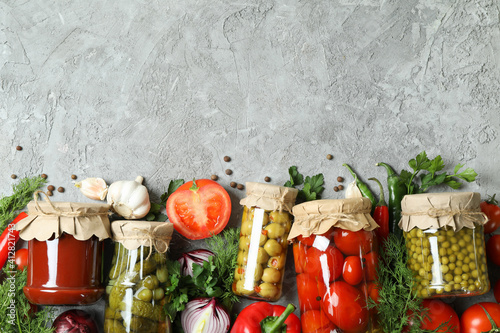 Different canned food and ingredients on gray background