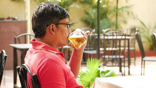 Man drinking wine at an restaurant, Man wearing glasses drinking wune photo