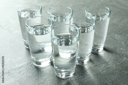 Shots with vodka on gray background, close up