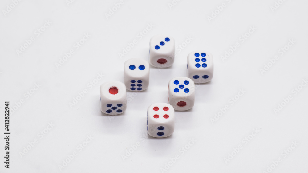 Heap of white cubic six dices with blue and red spikes (dots) on a white background. Game, gambling, chance and risk concept Heap of white cubic six dices with blue and red spikes (dots) on a white background. Game, gambling, chance and risk concept