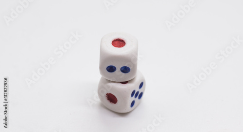 The cube is on the cube. Heap of white cubic dice with blue and red spikes (dots) on a white background. Game, gambling, chance and risk concept