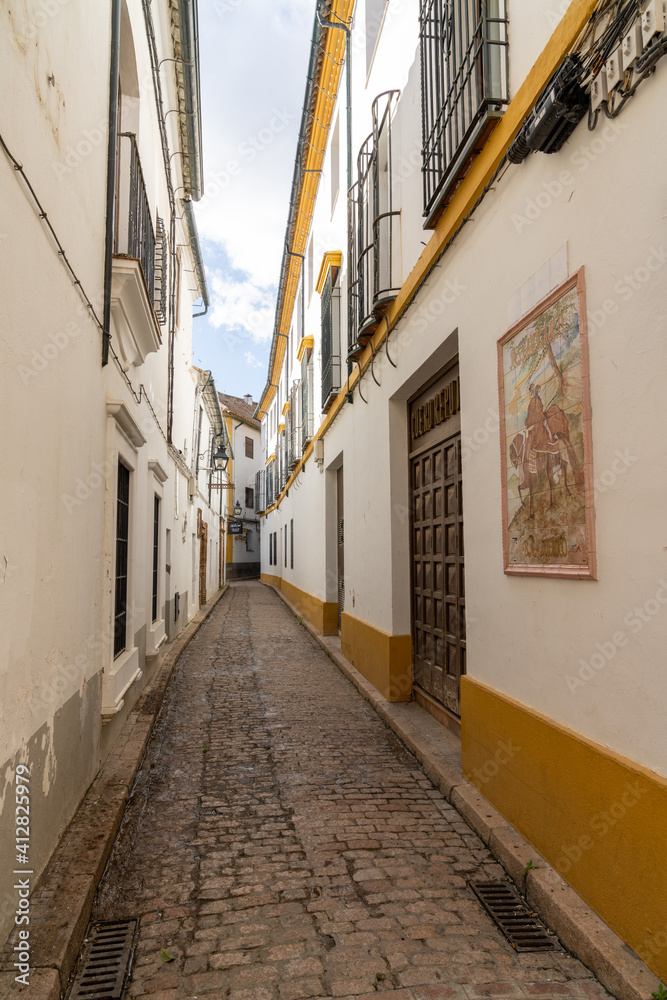 narrow and deserted city street in the old city center of Cordoba