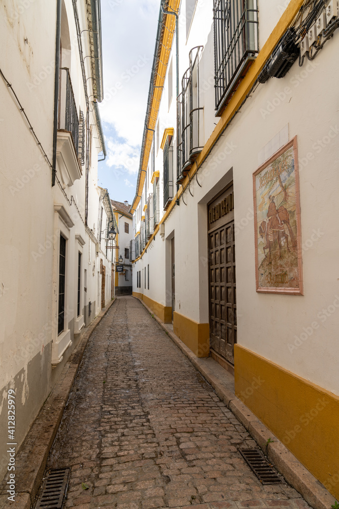 Fototapeta premium narrow and deserted city street in the old city center of Cordoba