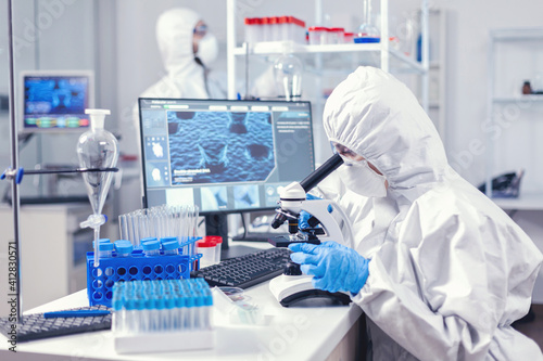 Photography Team of medical personal wearing ppe suit doing coronavirus analysis in modern laboratory
