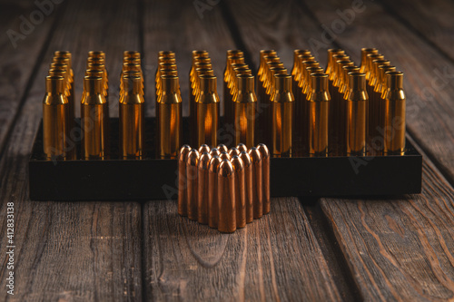 Heavy bullets for hunting and prepared casings on a wooden background, ammo reloading, soft focus photo