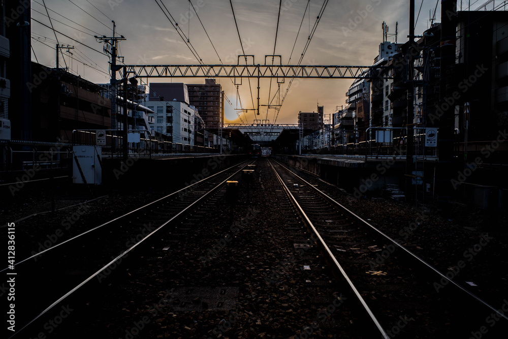 夕陽に輝く電車のレール。阪急電車岡本駅付近にて