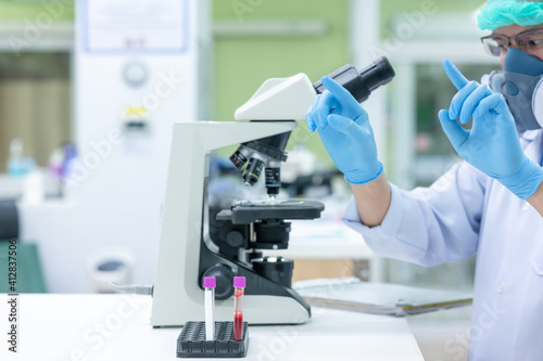 Scientists are studying research on the germs that cause COVID-19, the main cause of illness and are spreading in the world. (focus at tube)