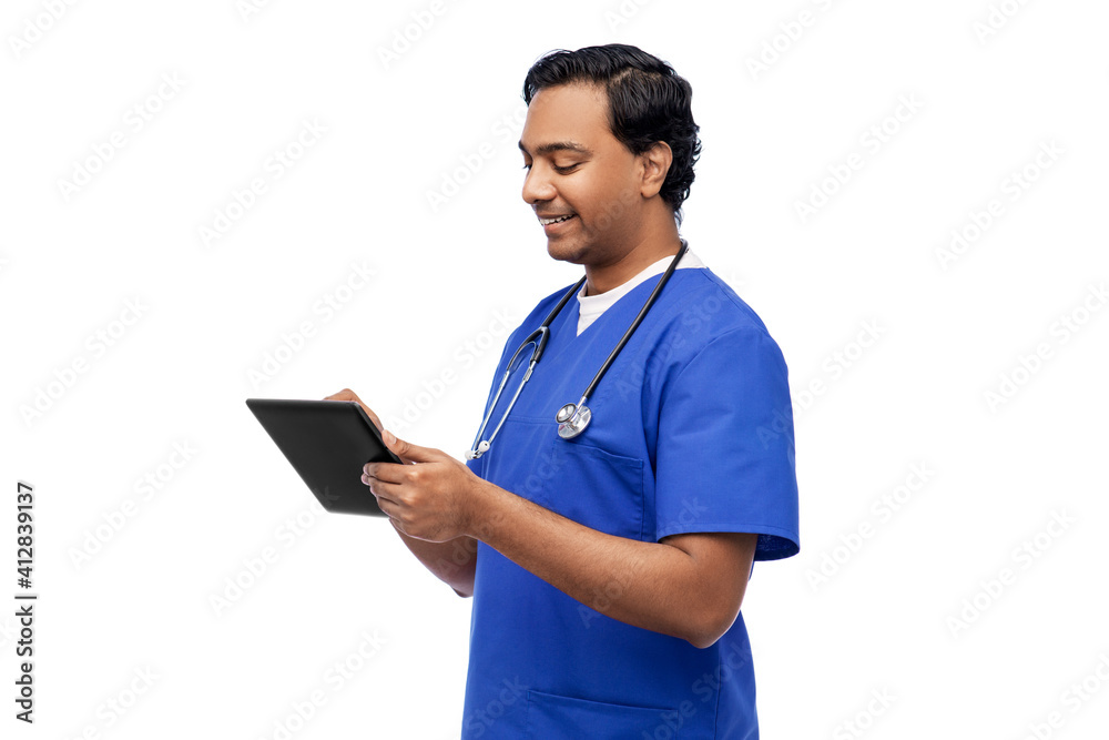 medicine, healthcare and technology concept - happy smiling indian doctor or male nurse in blue uniform with stethoscope using tablet pc computer over white background medicine, healthcare and technology concept - happy smiling indian doctor or male nurse in blue uniform with stethoscope using tablet pc computer over white background