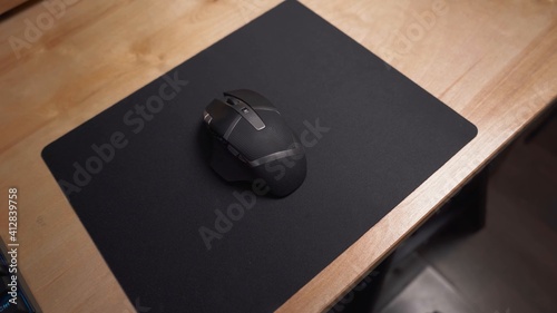 Slika na platnu Mouse gamer en color negro con varios botones, sobre mousepad de color negro