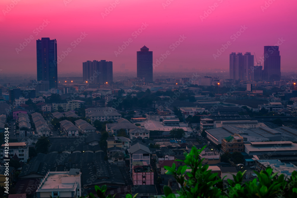 Fototapeta premium The blurred abstract background of the morning sun exposure to the tiny dust particles that surround the tall buildings in the capital, the long-term health issue of pollution