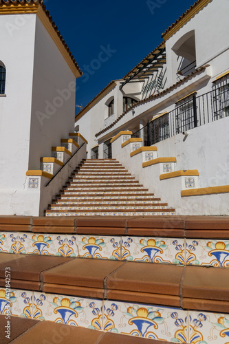 Spanish architecture style buildings with whitewashed walls and beautiful colorful tiled stairs © makasana photo
