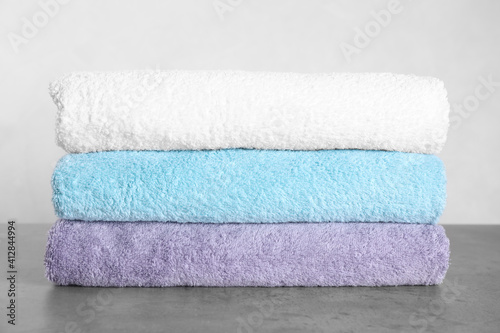Stack of clean fresh towels on grey table