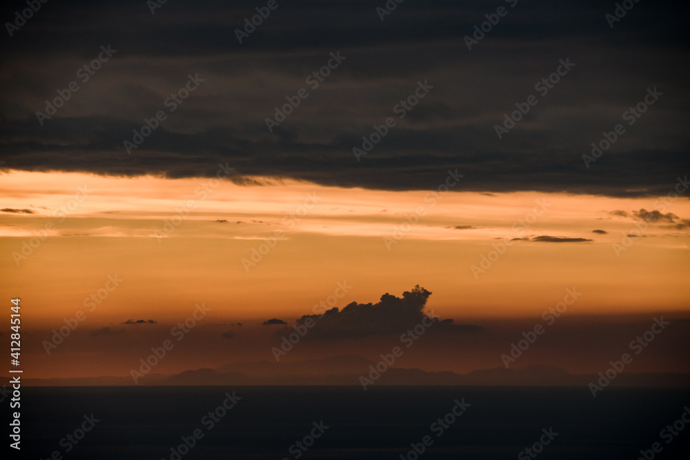beautiful view of clouds in orange sky above the ocean horizon line