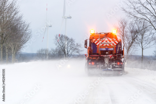 Räumfahrzeug auf schneebedeckter Straße im Winterdienst